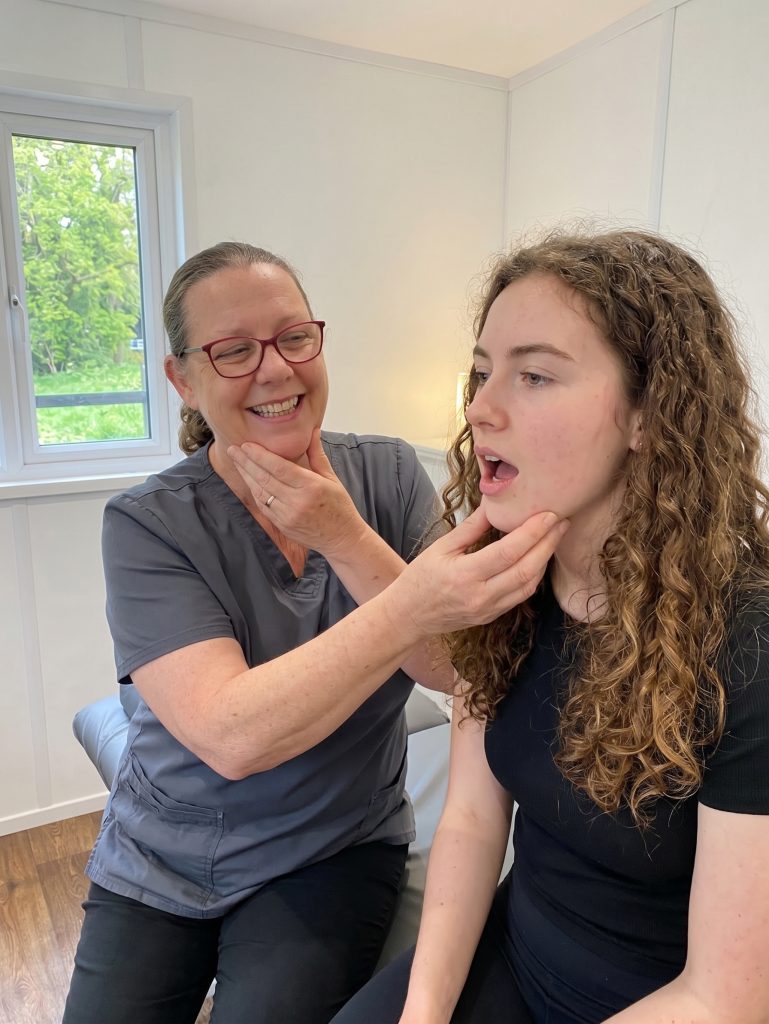 Jackie teaching jaw exercises to a female patient